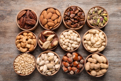 Flat lay composition with organic nuts on wooden background, top view. Snack mix