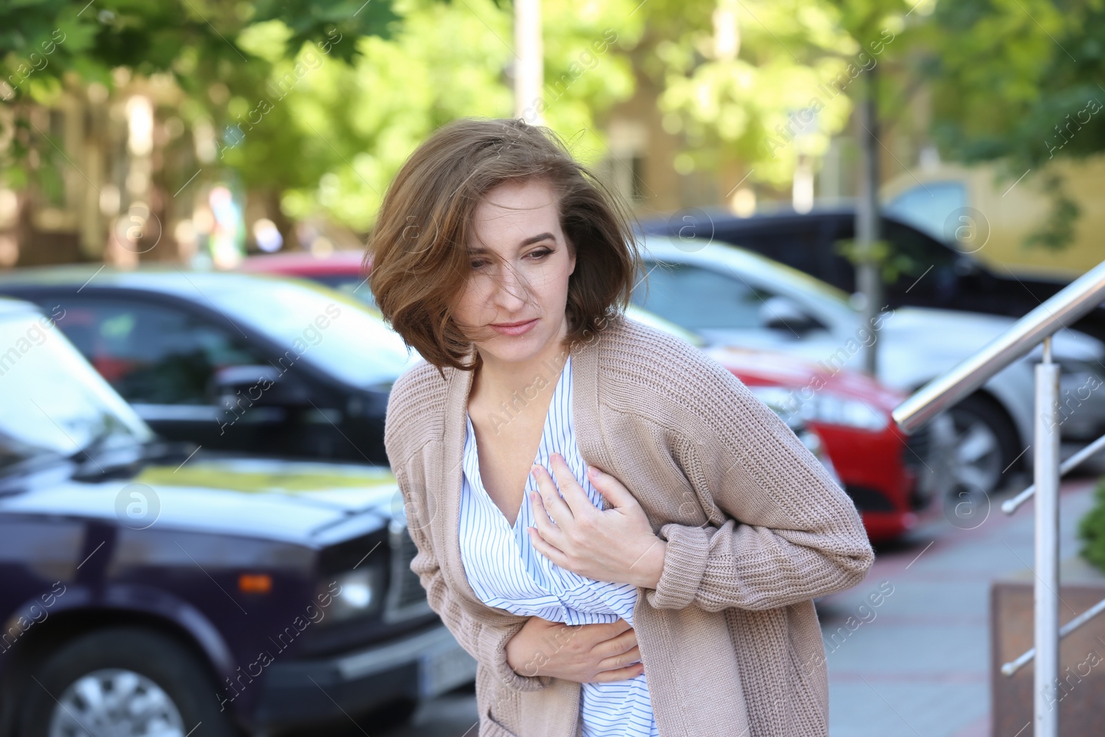 Photo of Mature woman having heart attack, outdoors