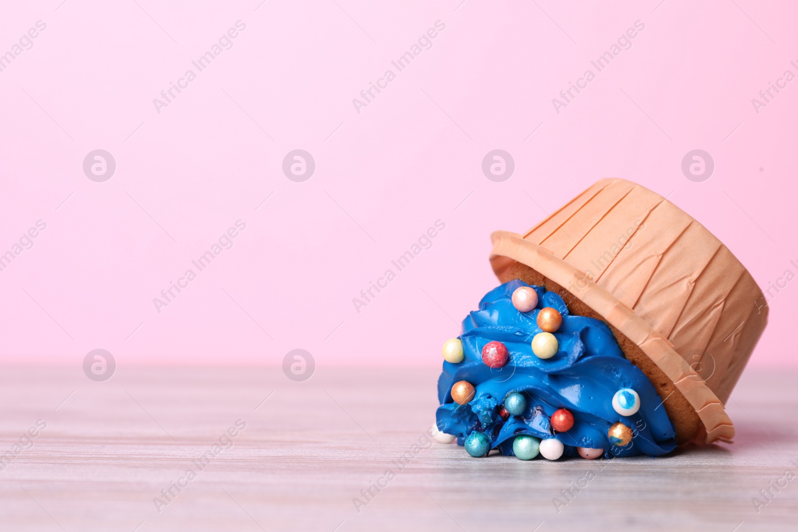 Photo of Dropped cupcake with cream on white wooden table, closeup. Troubles happen
