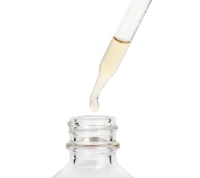 Photo of Essential oil dripping from pipette into glass bottle on white background