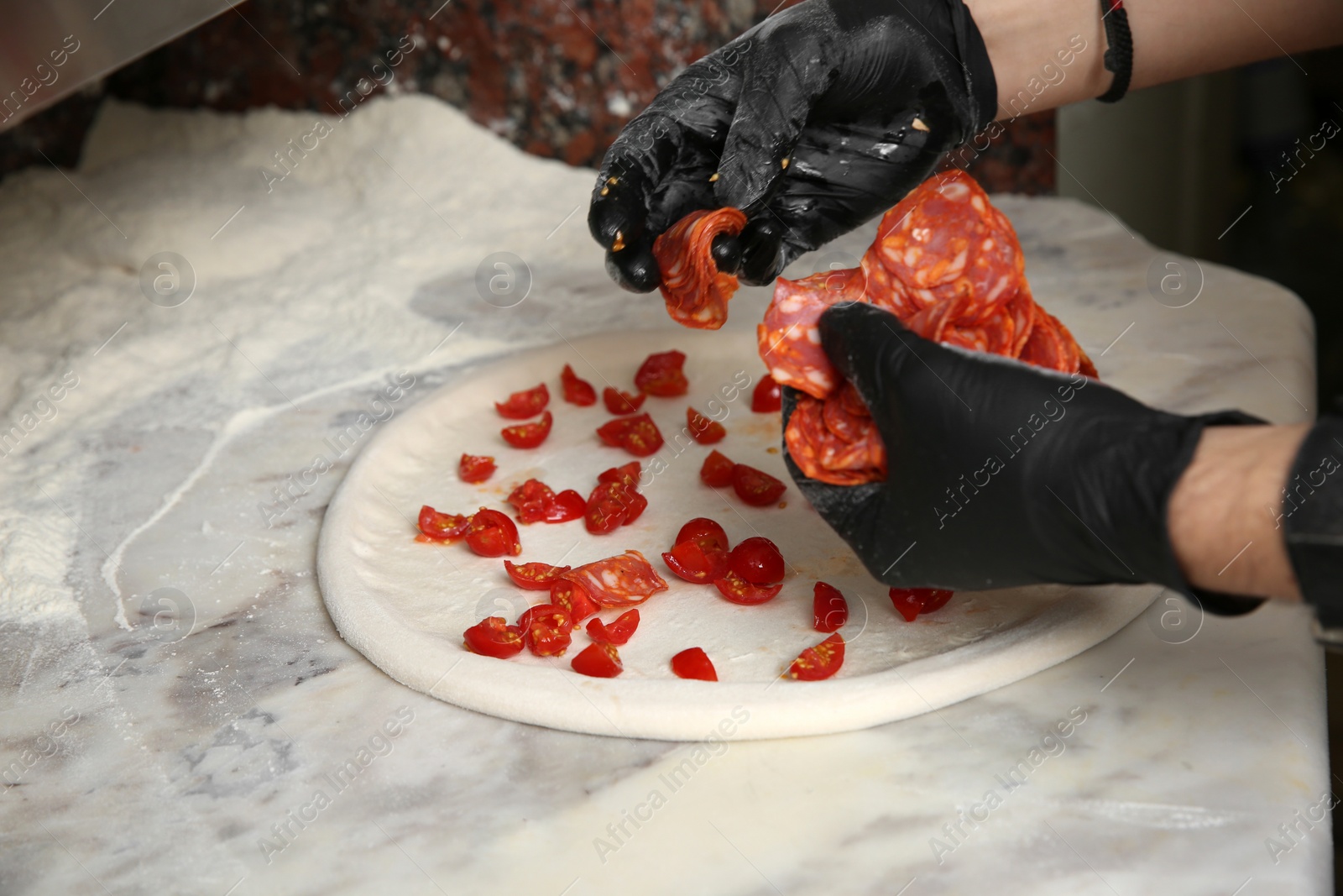 Photo of Professional chef preparing Italian pizza on table in restaurant, closeup