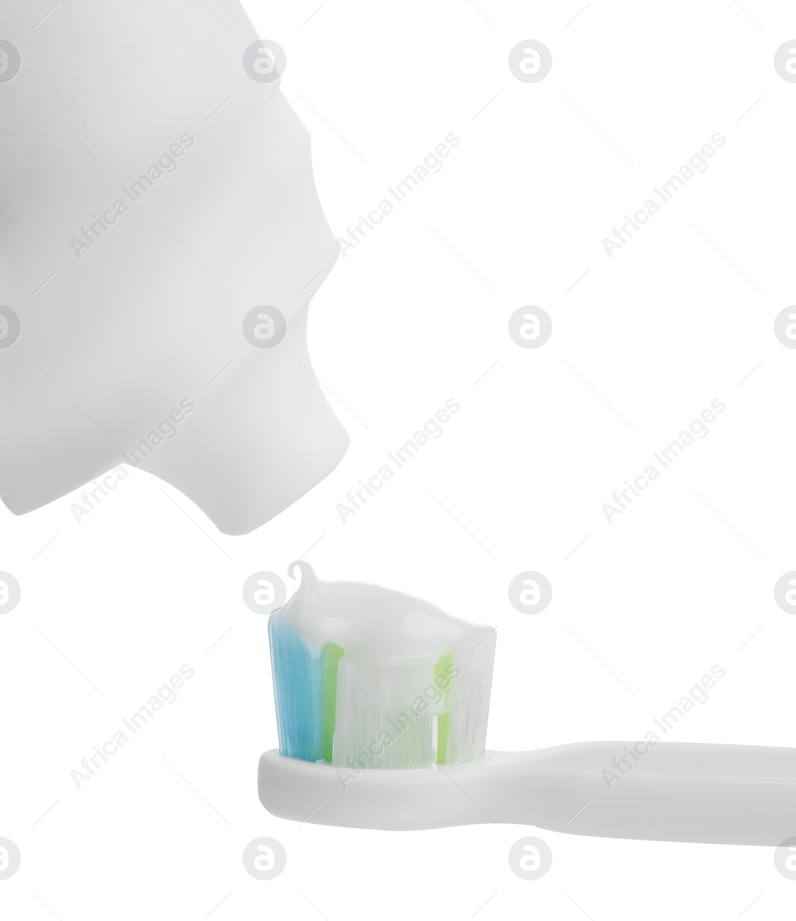 Photo of Applying paste on electric toothbrush against white background, closeup