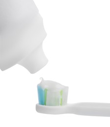 Photo of Applying paste on electric toothbrush against white background, closeup