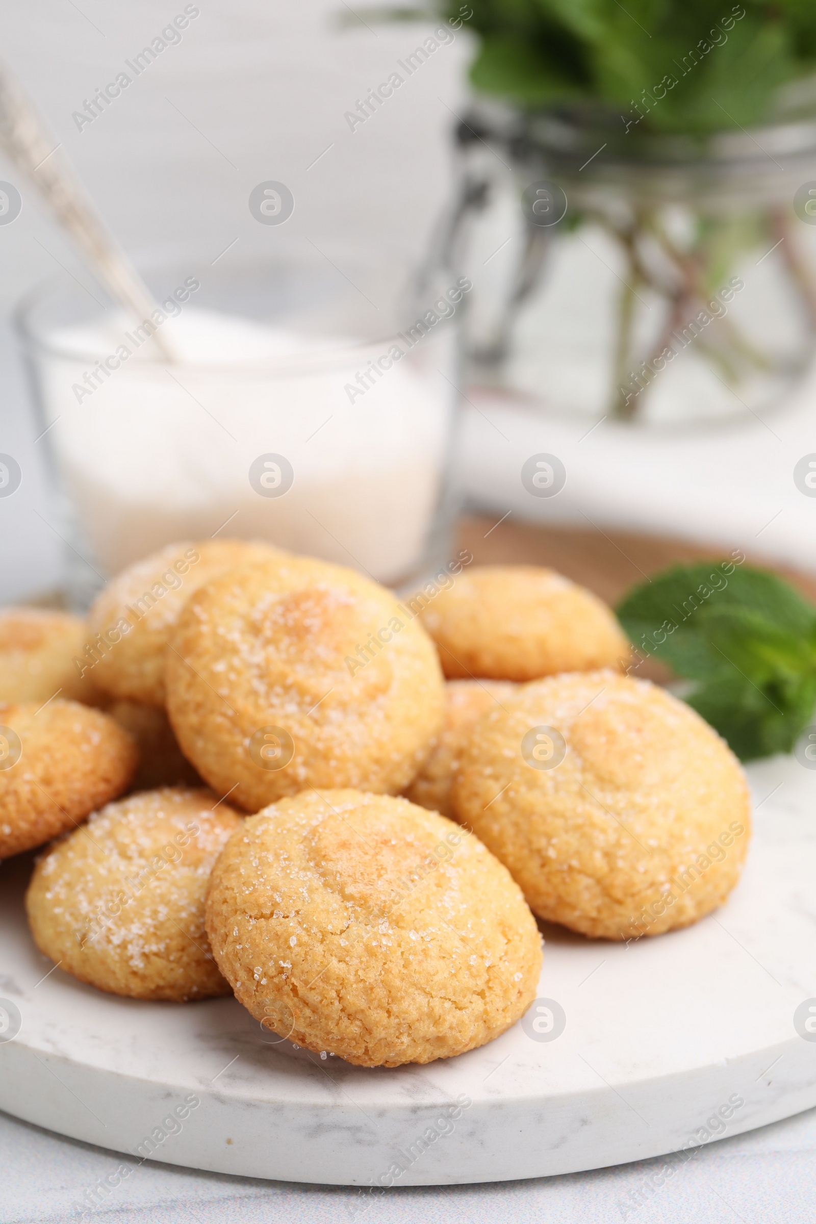 Photo of Tasty sweet sugar cookies, milk and mint on white table, closeup