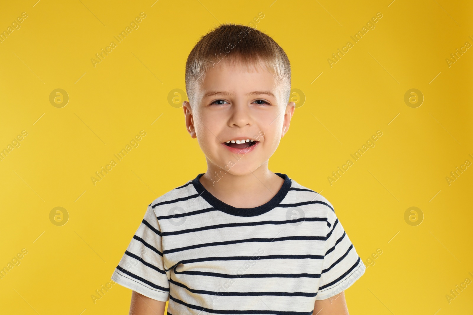 Photo of Portrait of happy little boy on yellow background