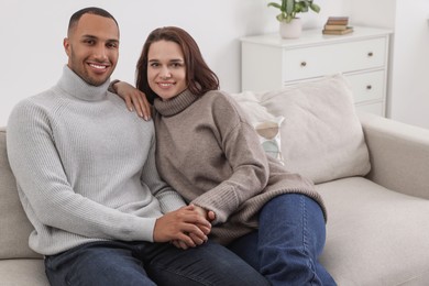 Dating agency. Happy couple holding hands on sofa at home