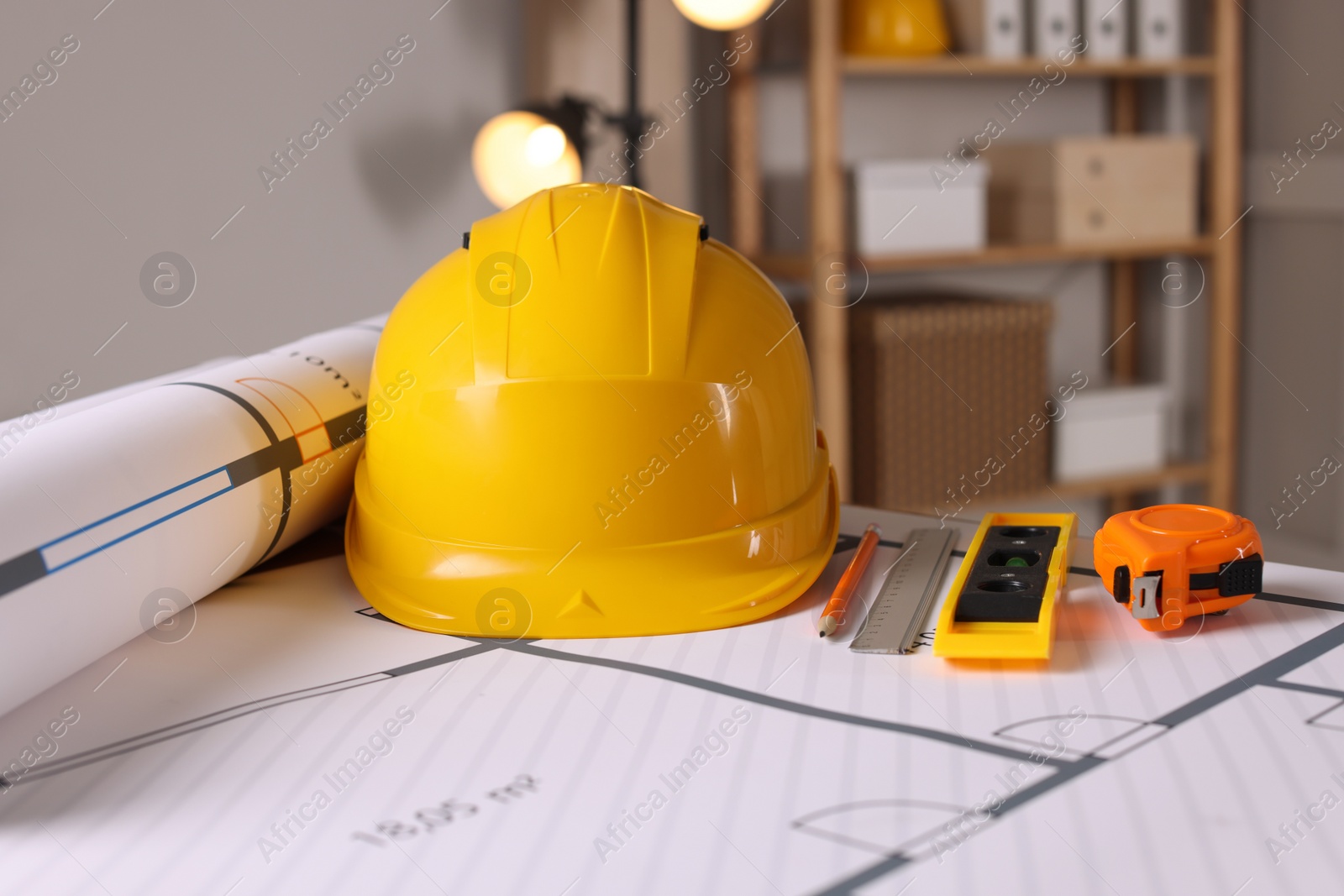 Photo of Construction drawings and different tools on table in office