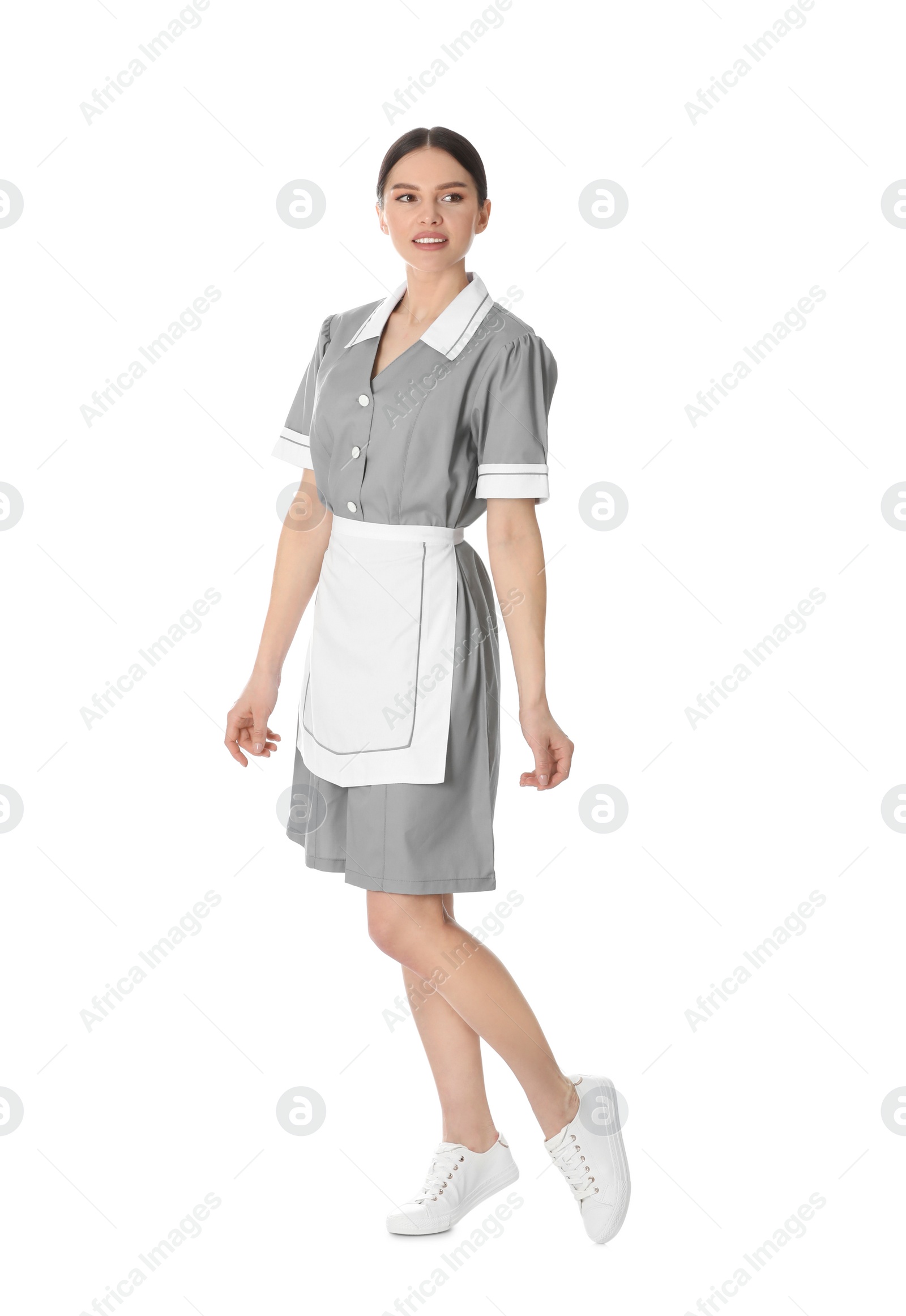 Photo of Young chambermaid in uniform on white background