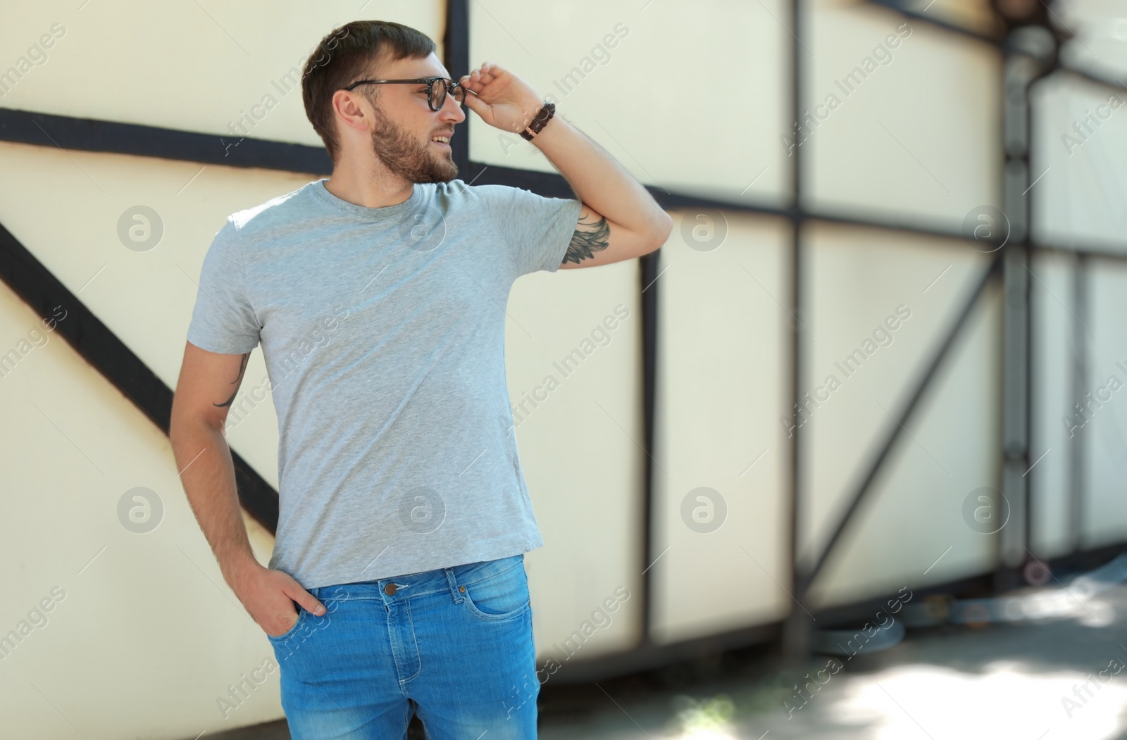 Photo of Young man wearing gray t-shirt on street. Urban style