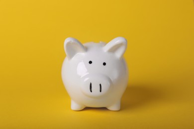 Photo of Ceramic piggy bank on yellow background. Financial savings