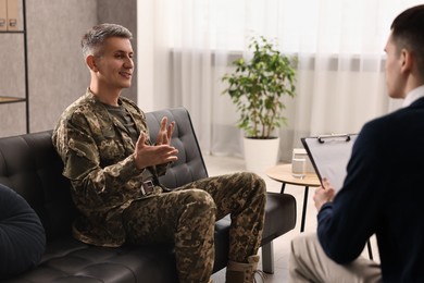 Photo of Professional psychotherapist working with military man in office