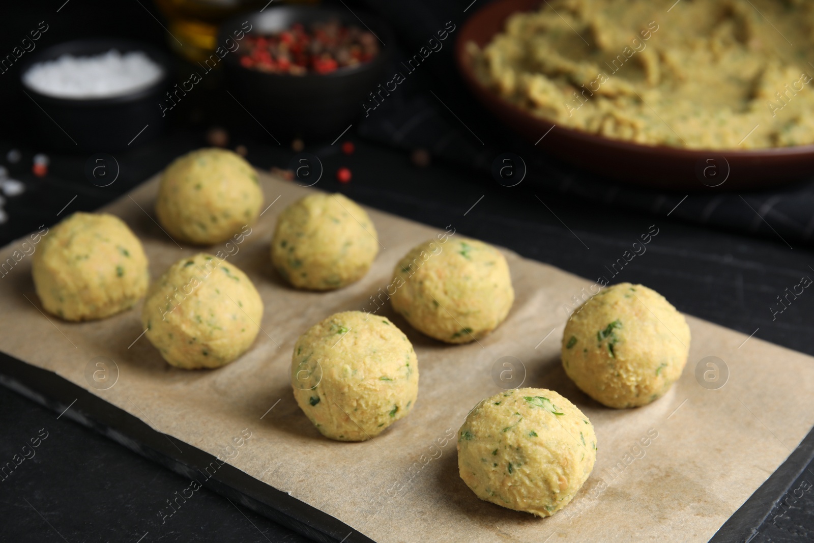 Photo of Many raw falafel balls on black table