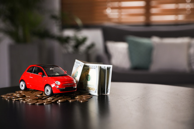 Photo of Miniature automobile model and money on table indoors, space for text. Car buying