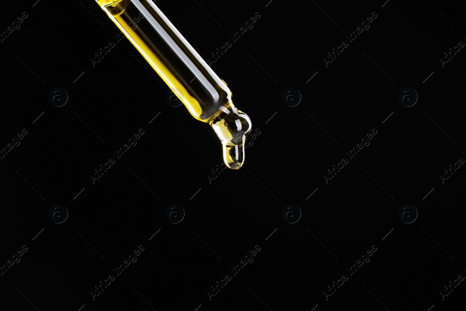 Photo of Dripping tincture from pipette on black background, closeup. Space for text