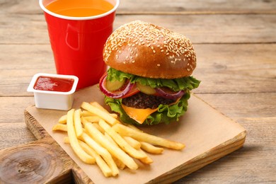 Photo of Burger, French fries, ketchup and refreshing drink on wooden table. Fast food