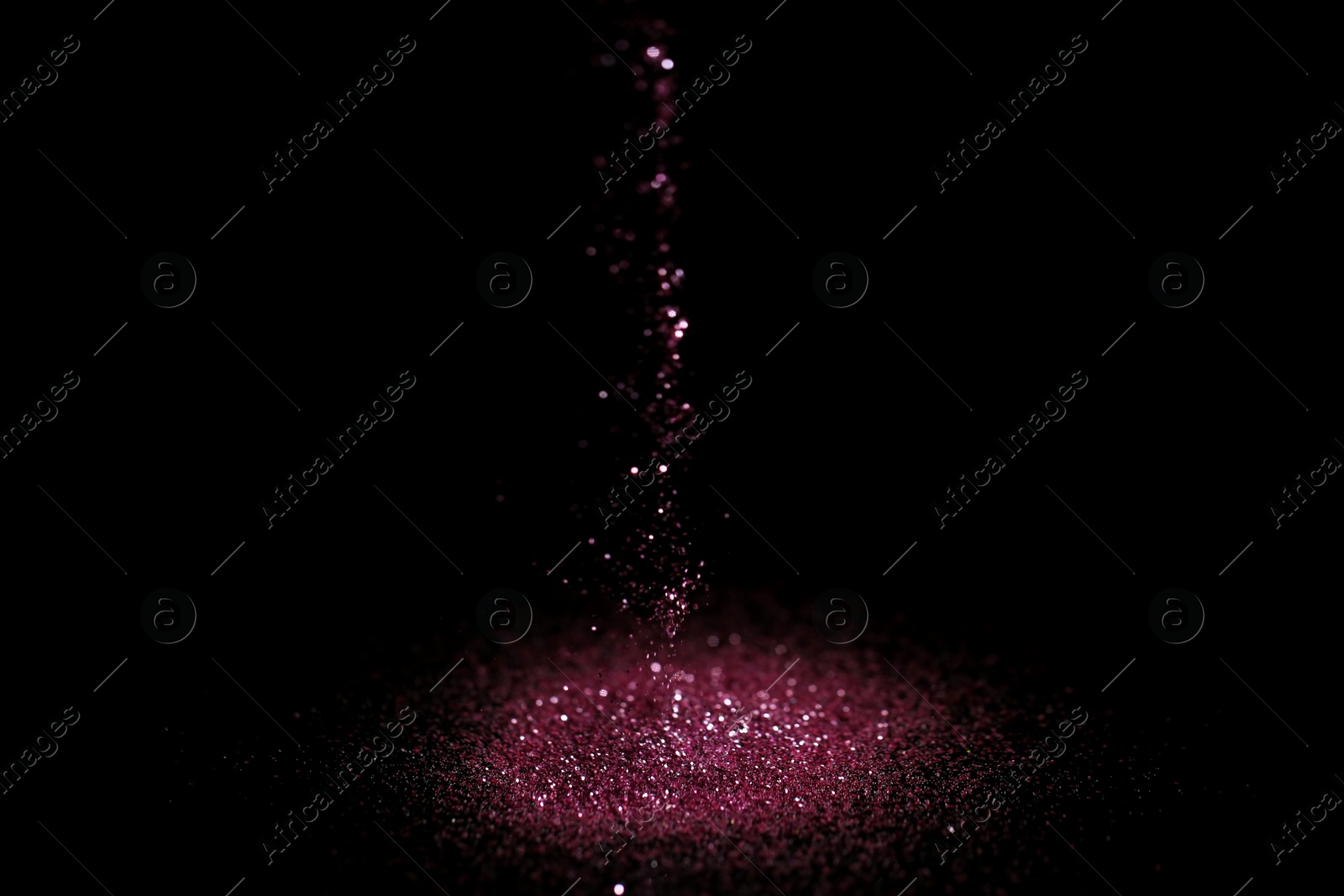 Photo of Sprinkling rose glitter on black background, bokeh effect