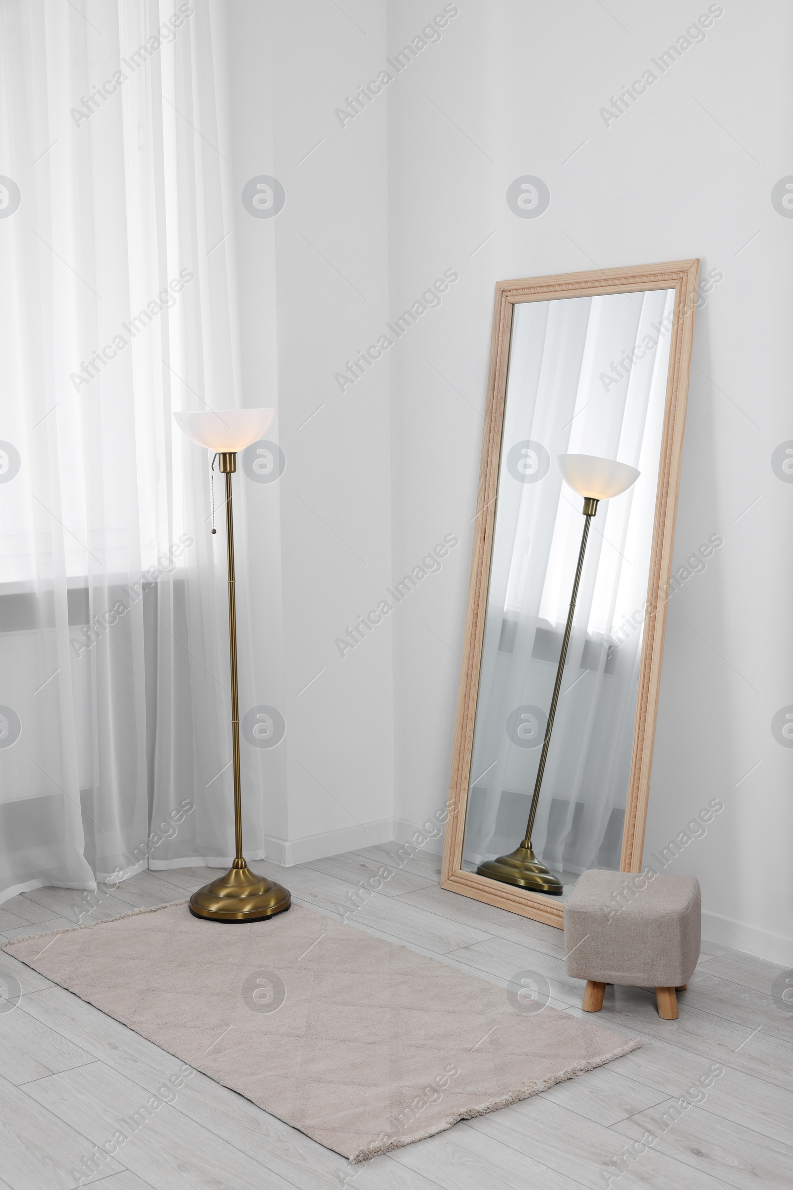 Photo of Stylish makeup room interior with long mirror and lamp