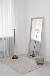 Photo of Stylish makeup room interior with long mirror and lamp