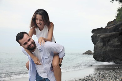 Photo of Happy young couple having fun on beach sea. Space for text