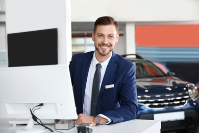 Photo of Salesman working in modern car dealership. Buying new auto
