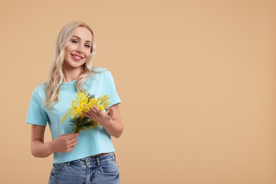 Photo of Happy young woman with beautiful bouquet on beige background. Space for text