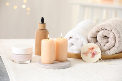 Photo of Spa composition. Burning candles and personal care products on soft surface