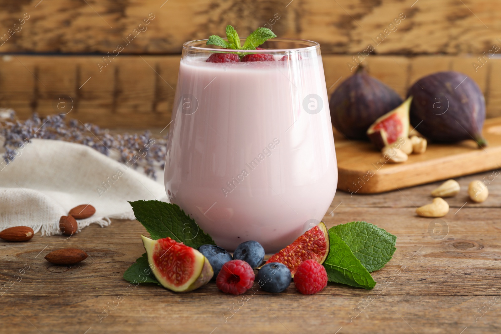 Photo of Delicious fig smoothie in glass on wooden table