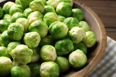 Fresh Brussels sprouts in bowl on table, closeup