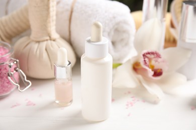 Photo of Composition with spa cosmetic and orchid flower on white wooden table, closeup