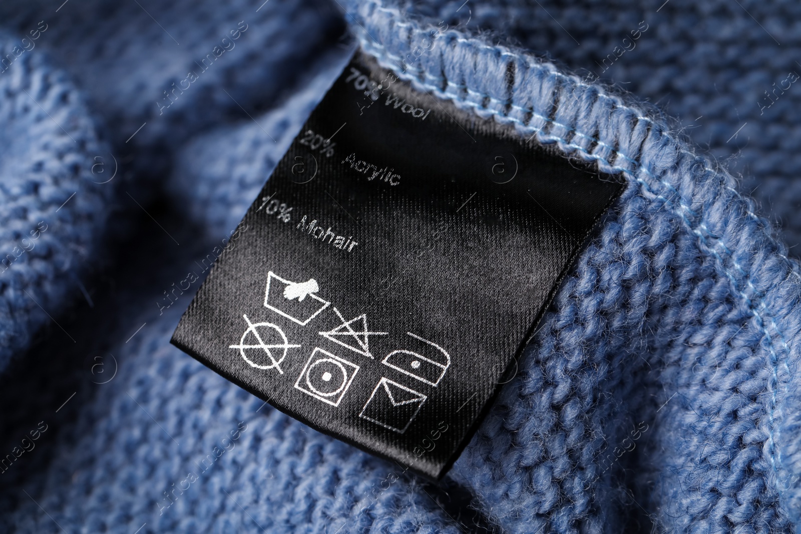 Photo of Clothing label on blue knitted garment, closeup