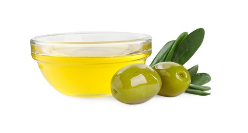 Photo of Cooking oil in glass bowl, olives and leaves on white background