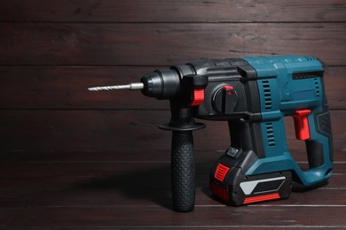 Photo of Modern electric power drill on wooden table