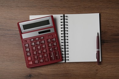 Calculator and office stationery on wooden table, top view