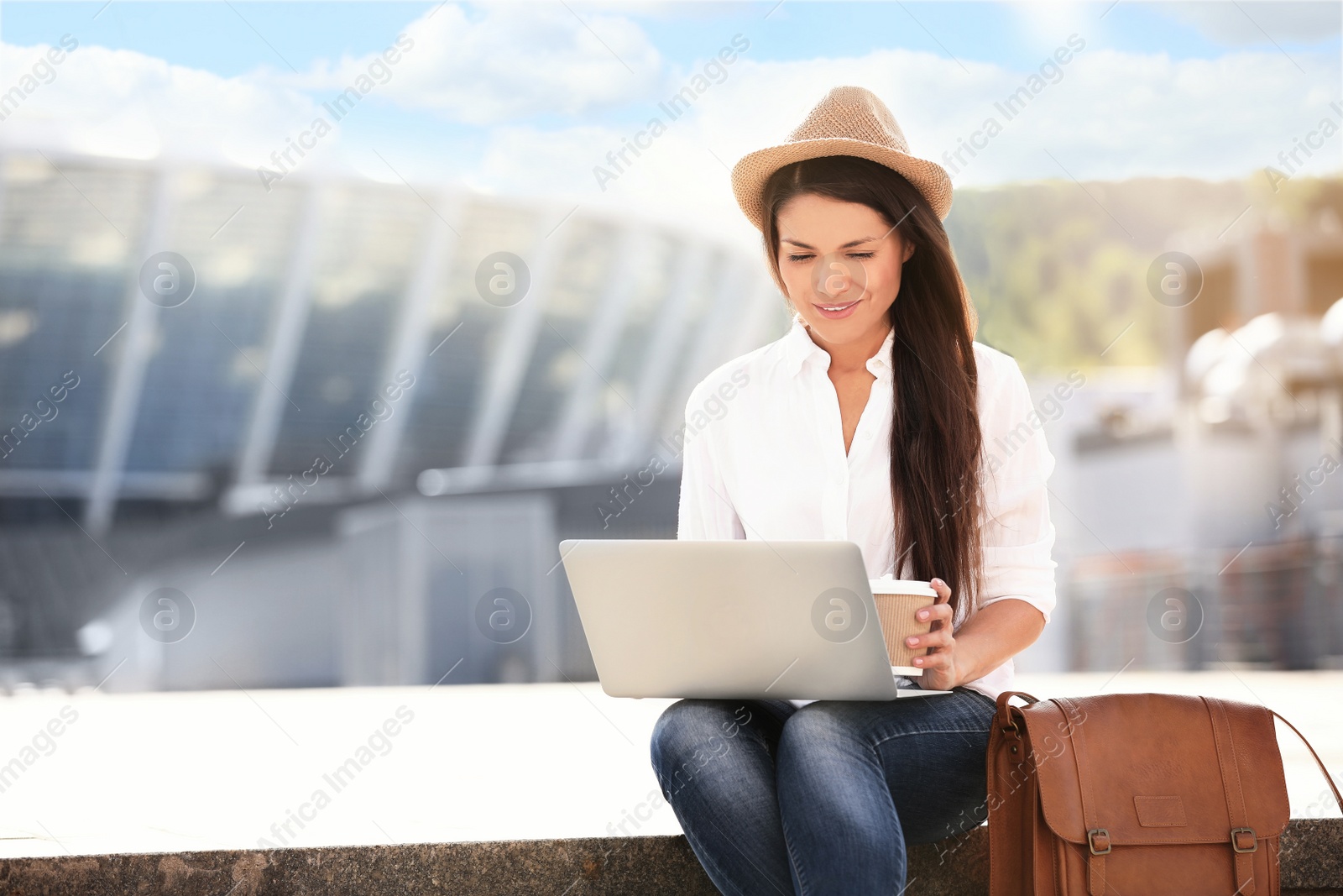 Photo of Beautiful woman with laptop sitting on stairs outdoors. Space for text