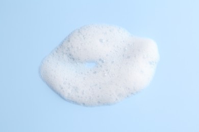 Photo of Sample of fluffy foam on light blue background, top view