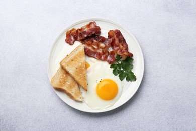 Delicious breakfast with sunny side up egg on light table, top view