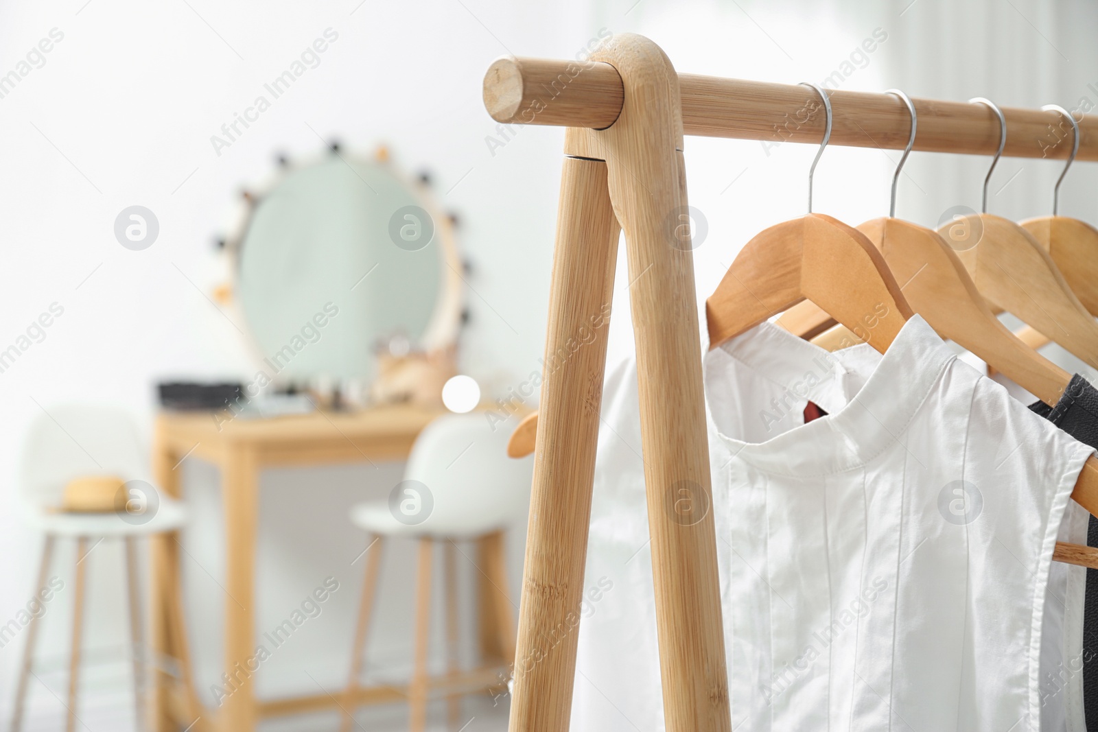 Photo of Hangers with stylish clothes on rack in makeup room. Space for text