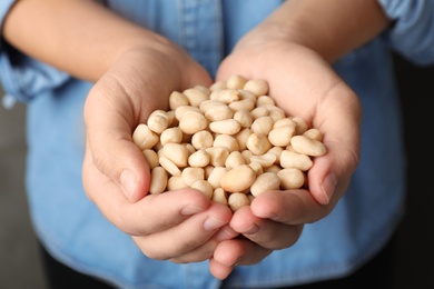 Woman holding shelled peanuts in hands, closeup