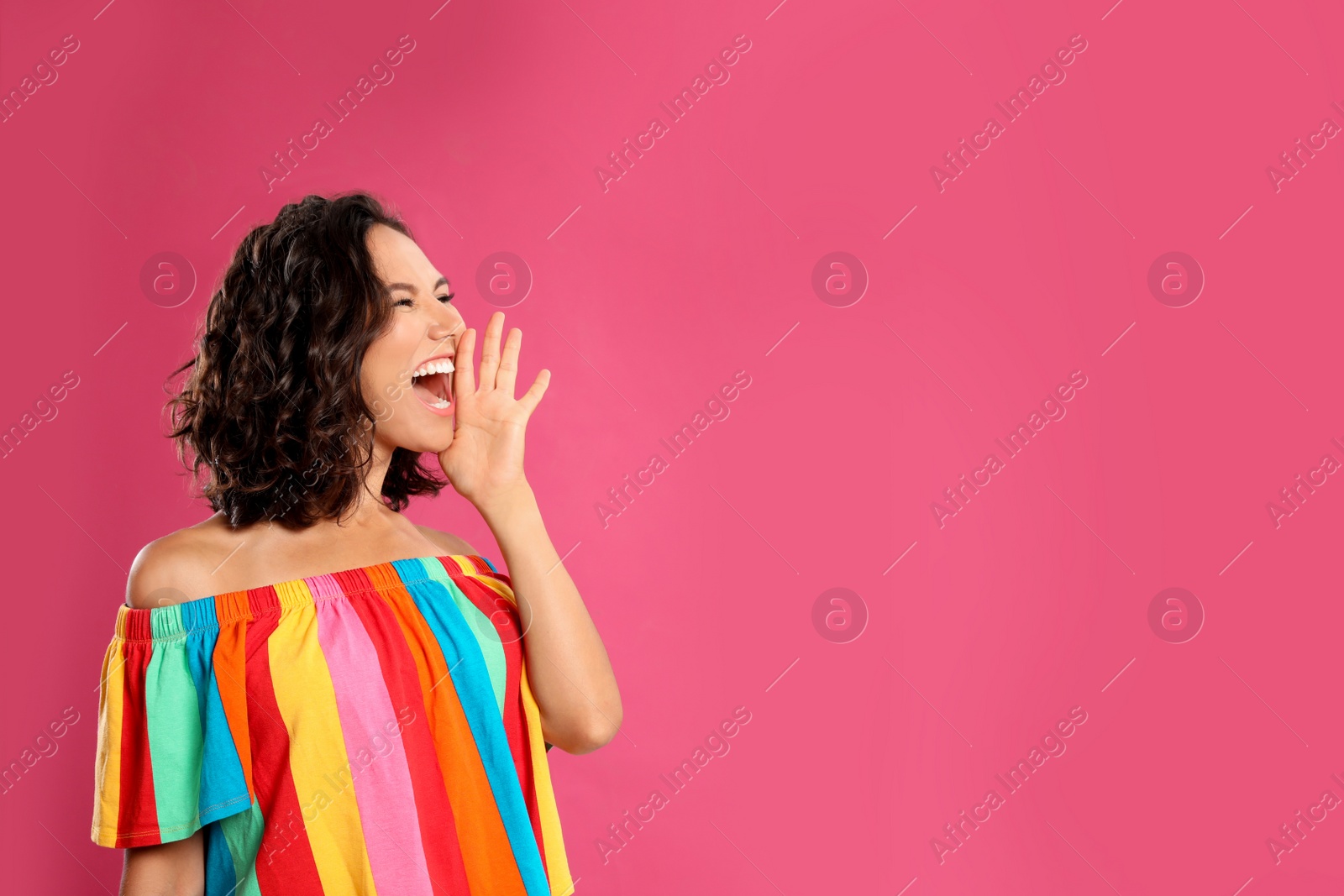 Photo of Beautiful young woman screaming on pink background. Space for text