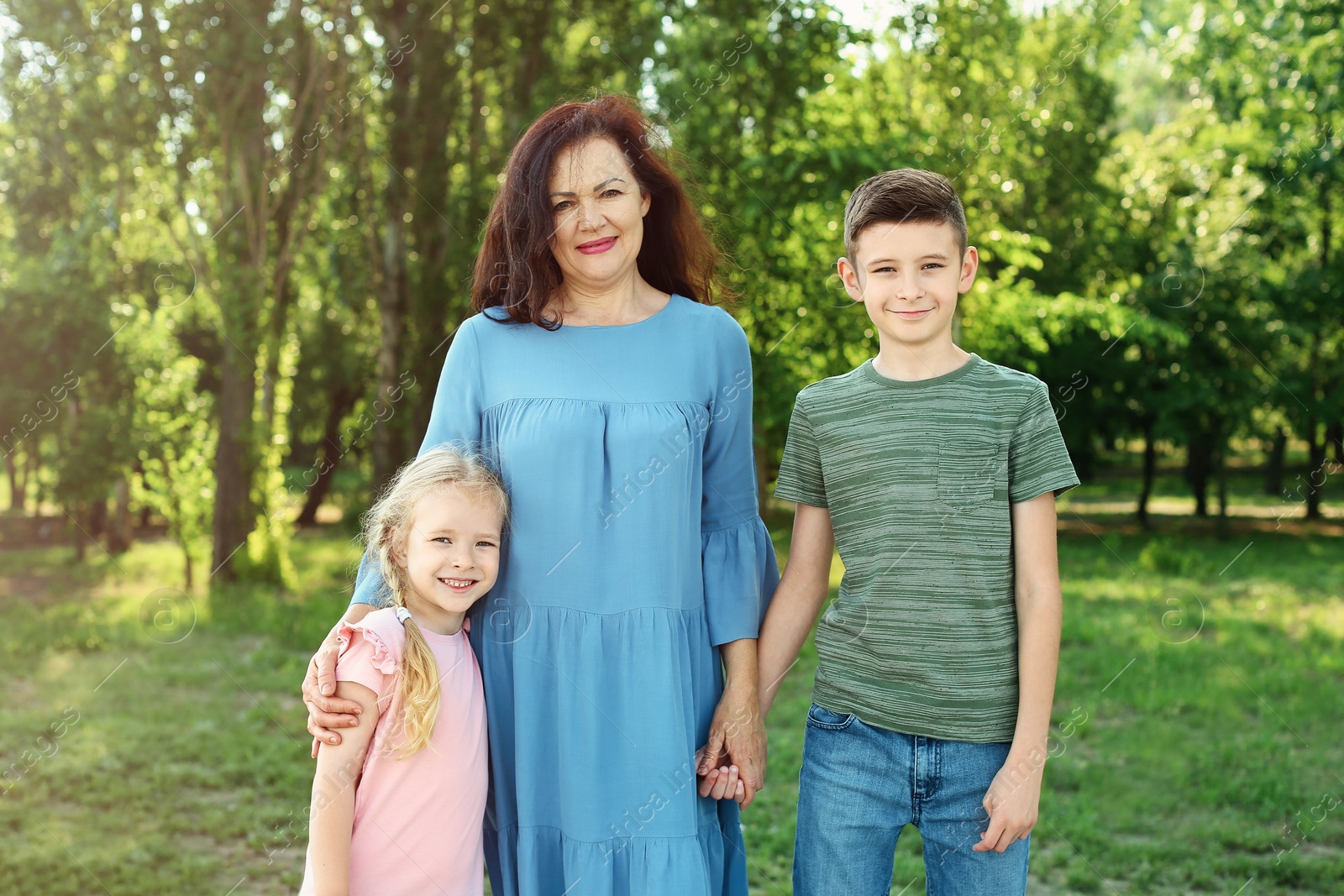 Photo of Female pensioner with grandchildren walking in park