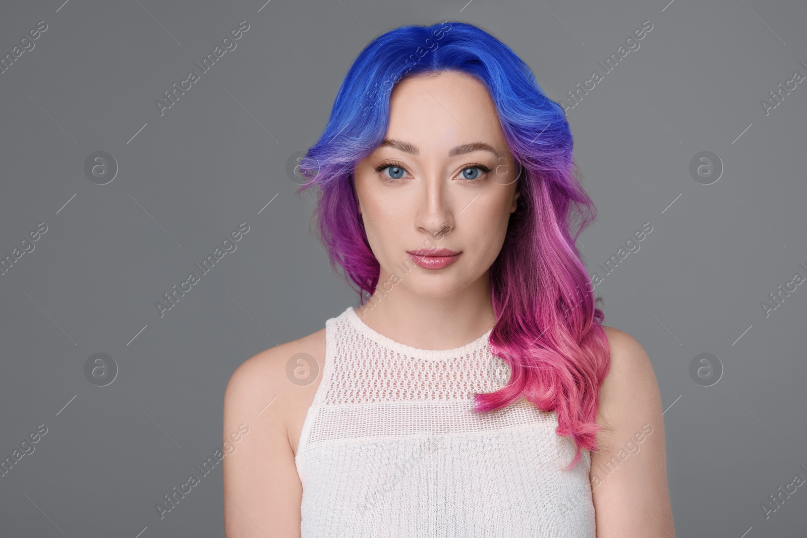 Image of Trendy hairstyle. Young woman with colorful dyed hair on grey background