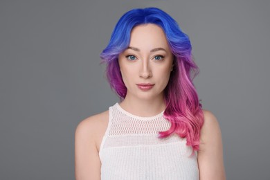 Image of Trendy hairstyle. Young woman with colorful dyed hair on grey background