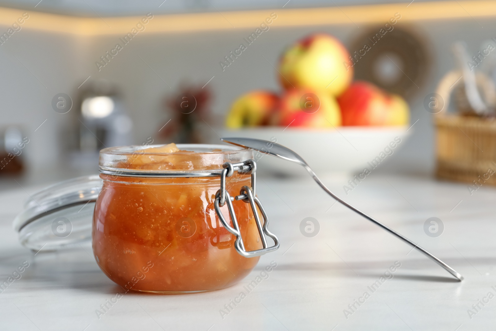 Photo of Delicious apple jam in jar on white table