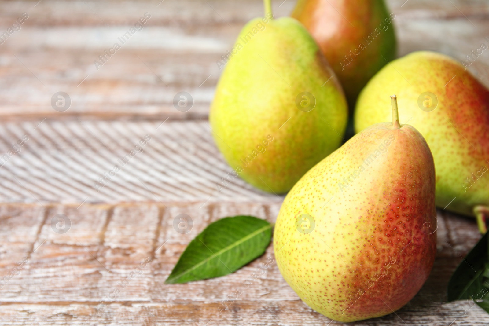 Photo of Ripe juicy pears on brown wooden table, closeup. Space for text