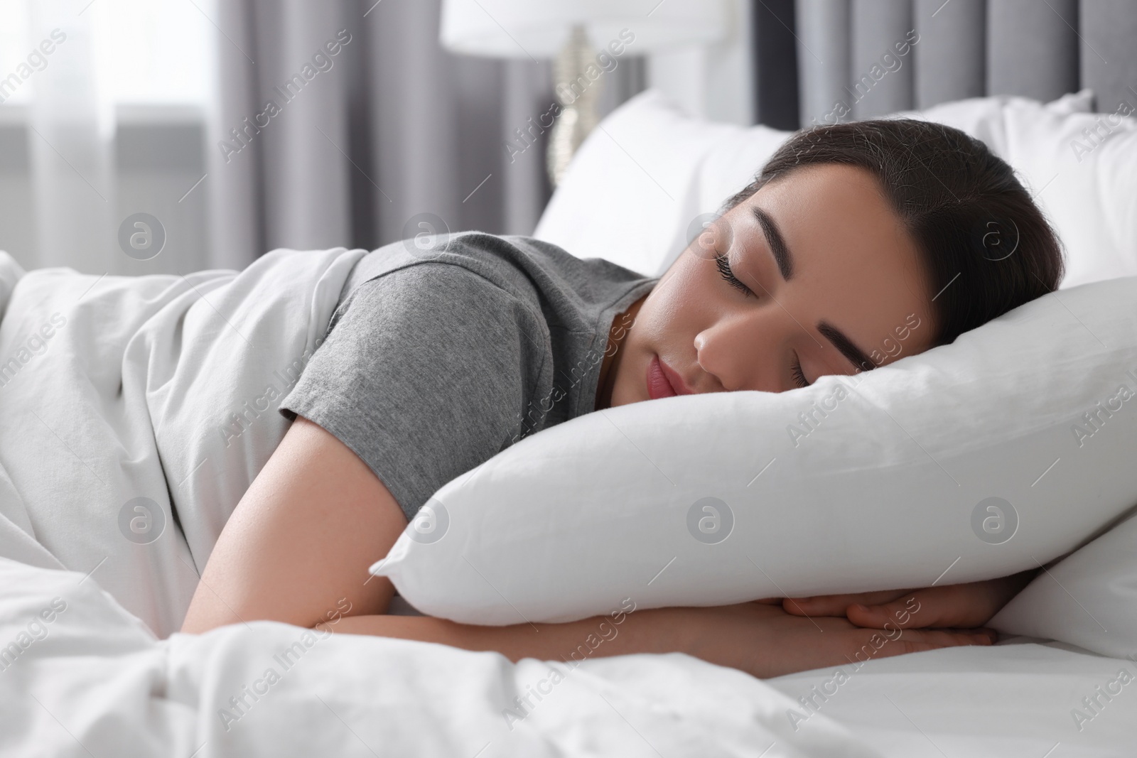 Photo of Beautiful young woman sleeping in soft bed at home