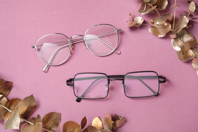 Photo of Different stylish glasses on pink background, flat lay