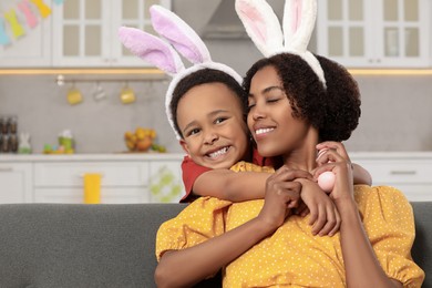 Photo of Happy African American mother and her cute son with Easter eggs indoors