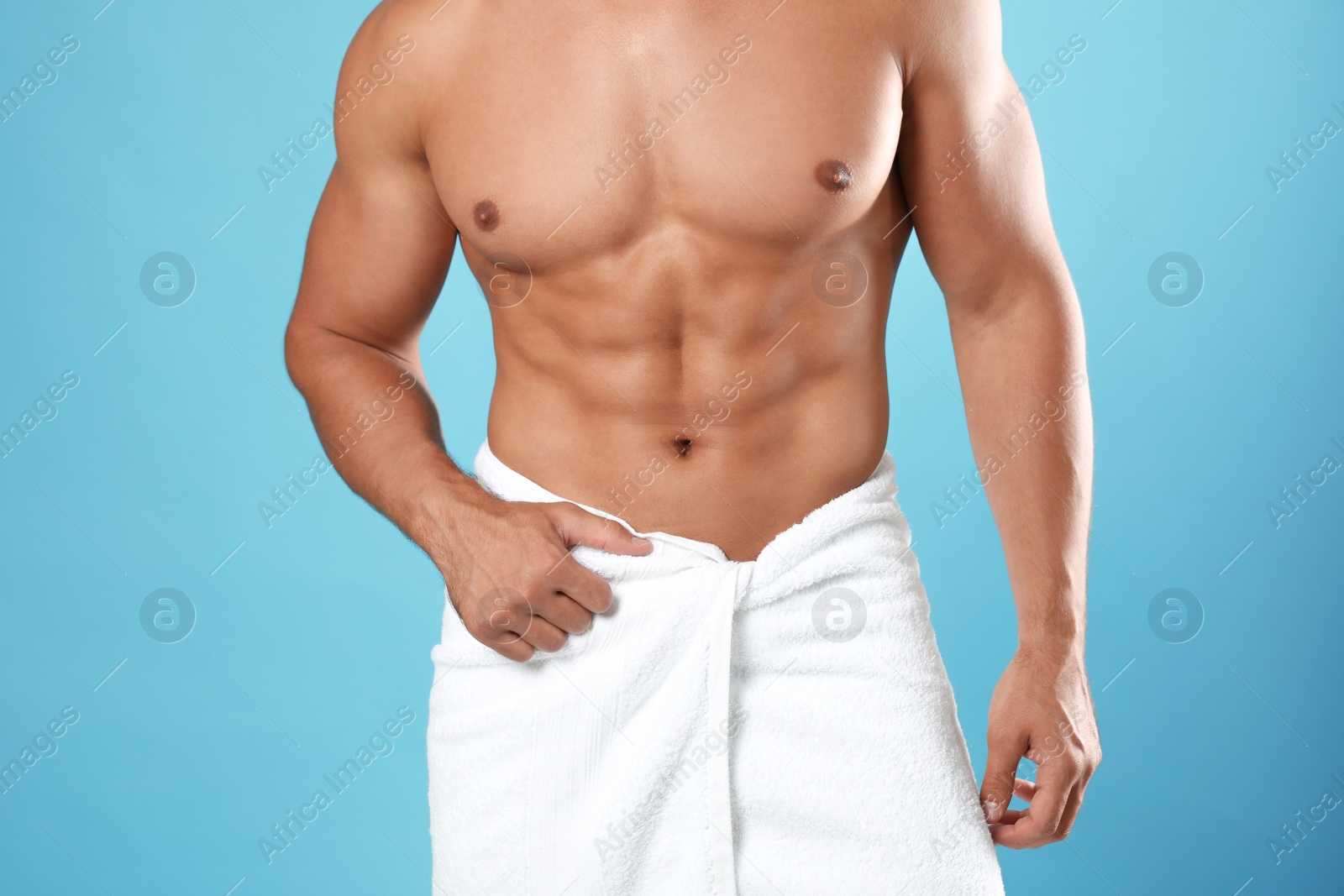 Photo of Young man with slim body on light blue background, closeup view