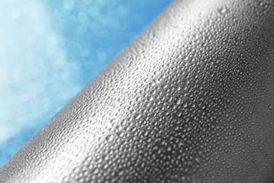 Photo of Aluminum sports water bottle covered with drops, closeup