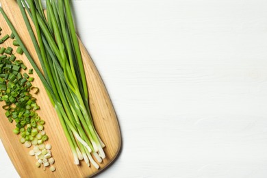 Photo of Fresh green onion on white wooden table, top view. Space for text